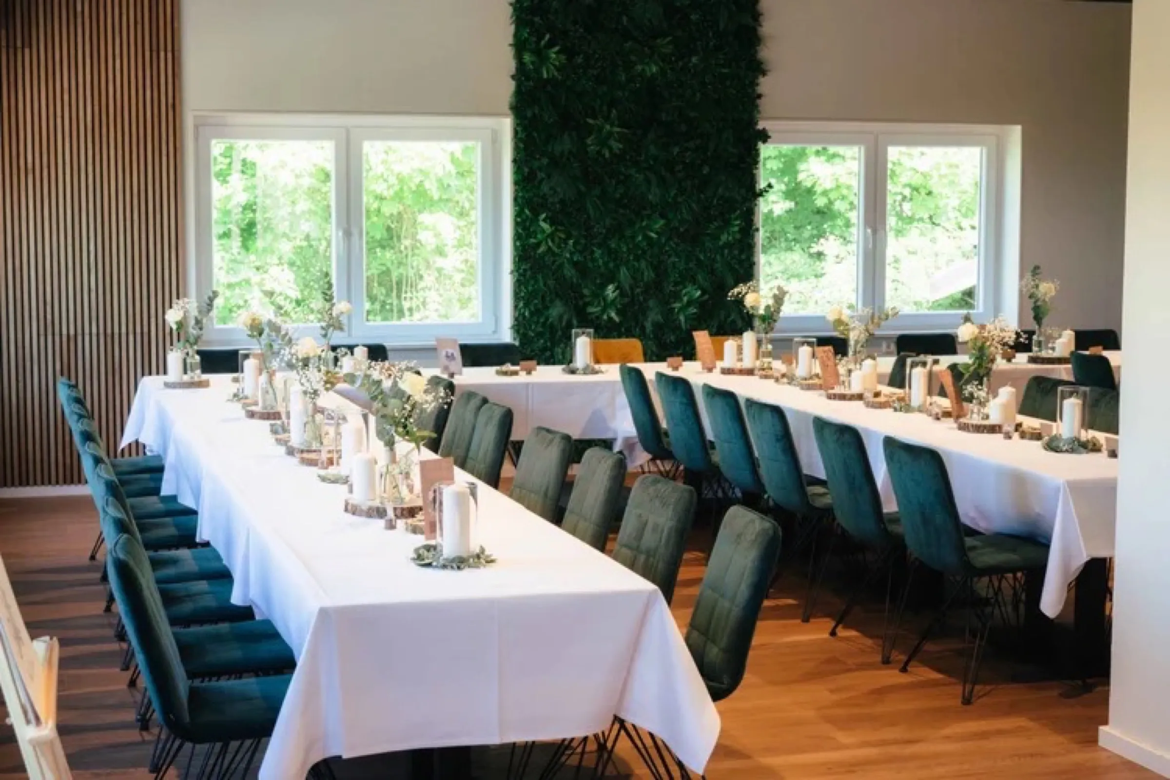 Heller Festsaal mit eingedeckten Tafeln